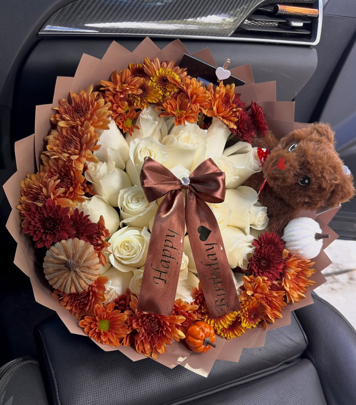 White roses ringed with orange fall florals and a printed Happy Birthday ribbon